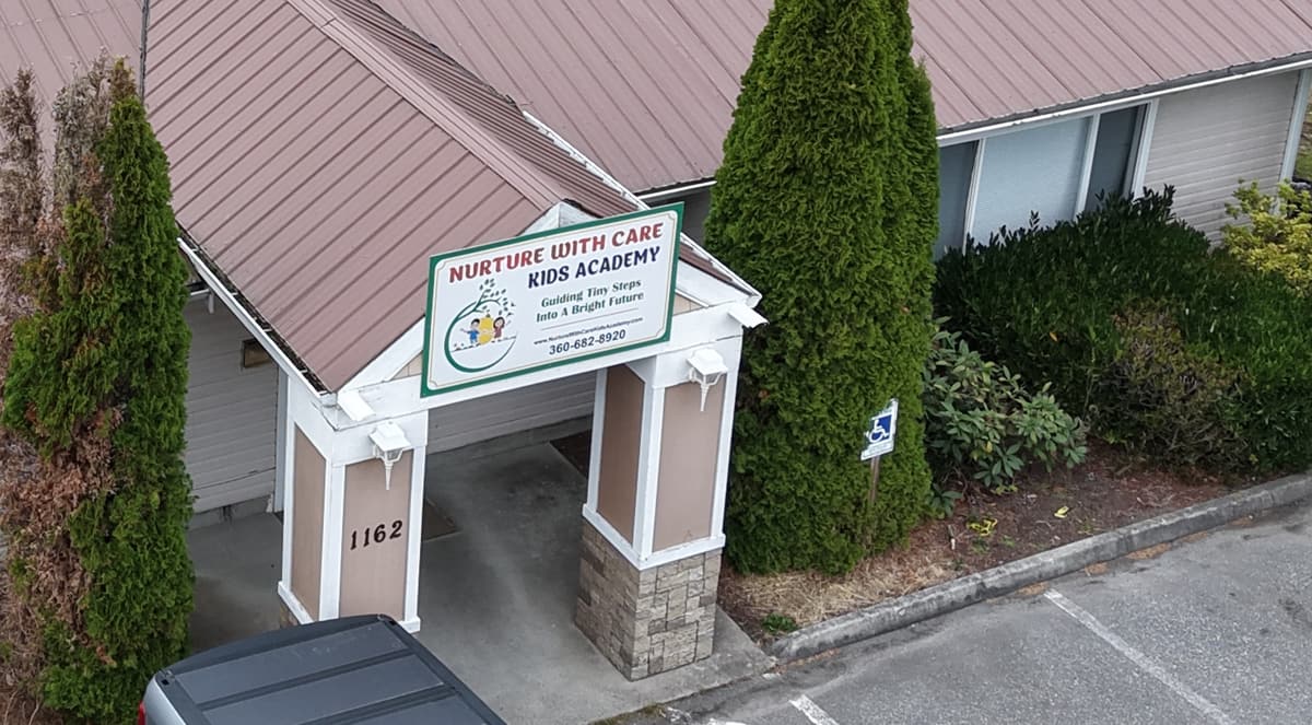 The Nurture with Care Kids Academy sign above the covered entrance at 1162 SW Fort Nugent Ave
