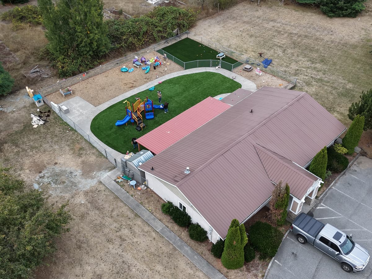 Aerial view of the Fort Nugent building with the main turf play yard, the covered patio and the second fenced yard behind it