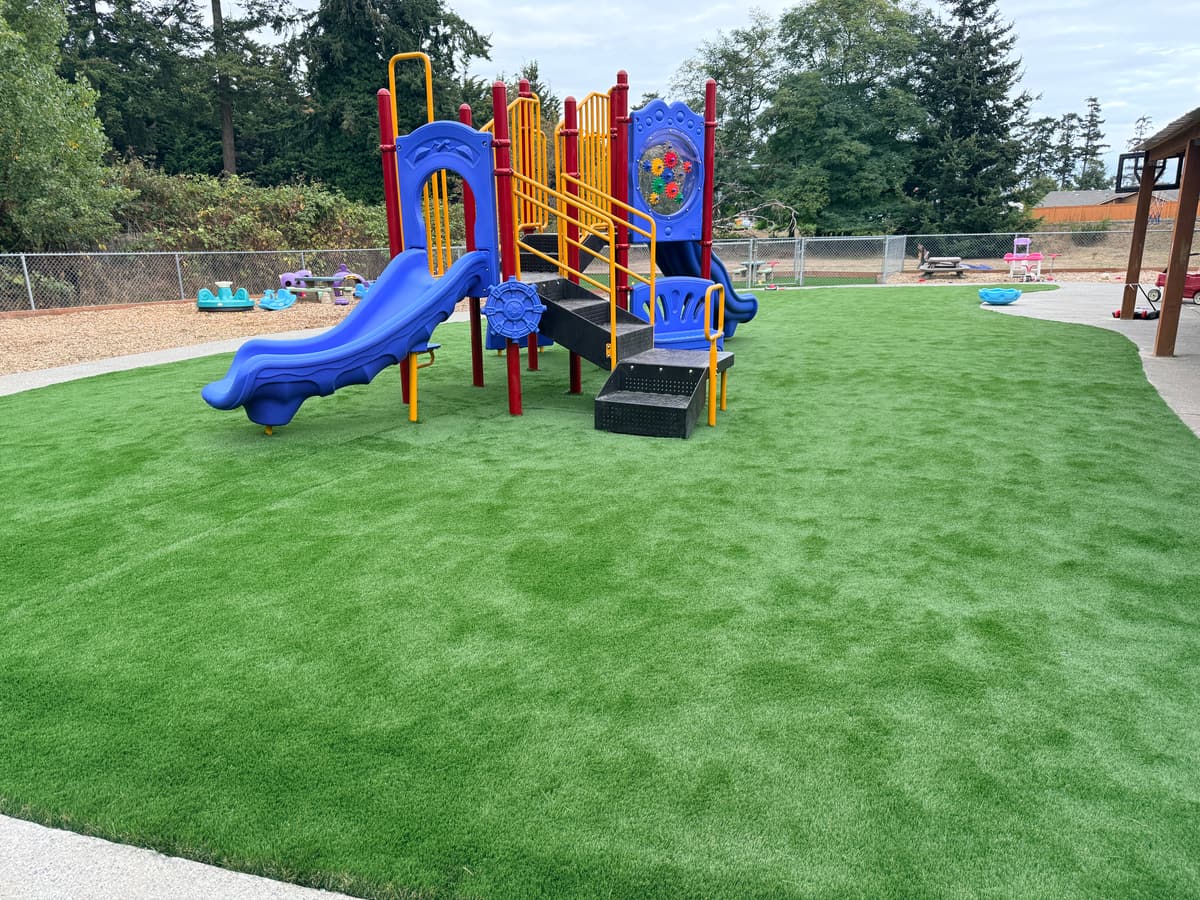 Ground level view of the new artificial turf and the play structure at the Fort Nugent playground