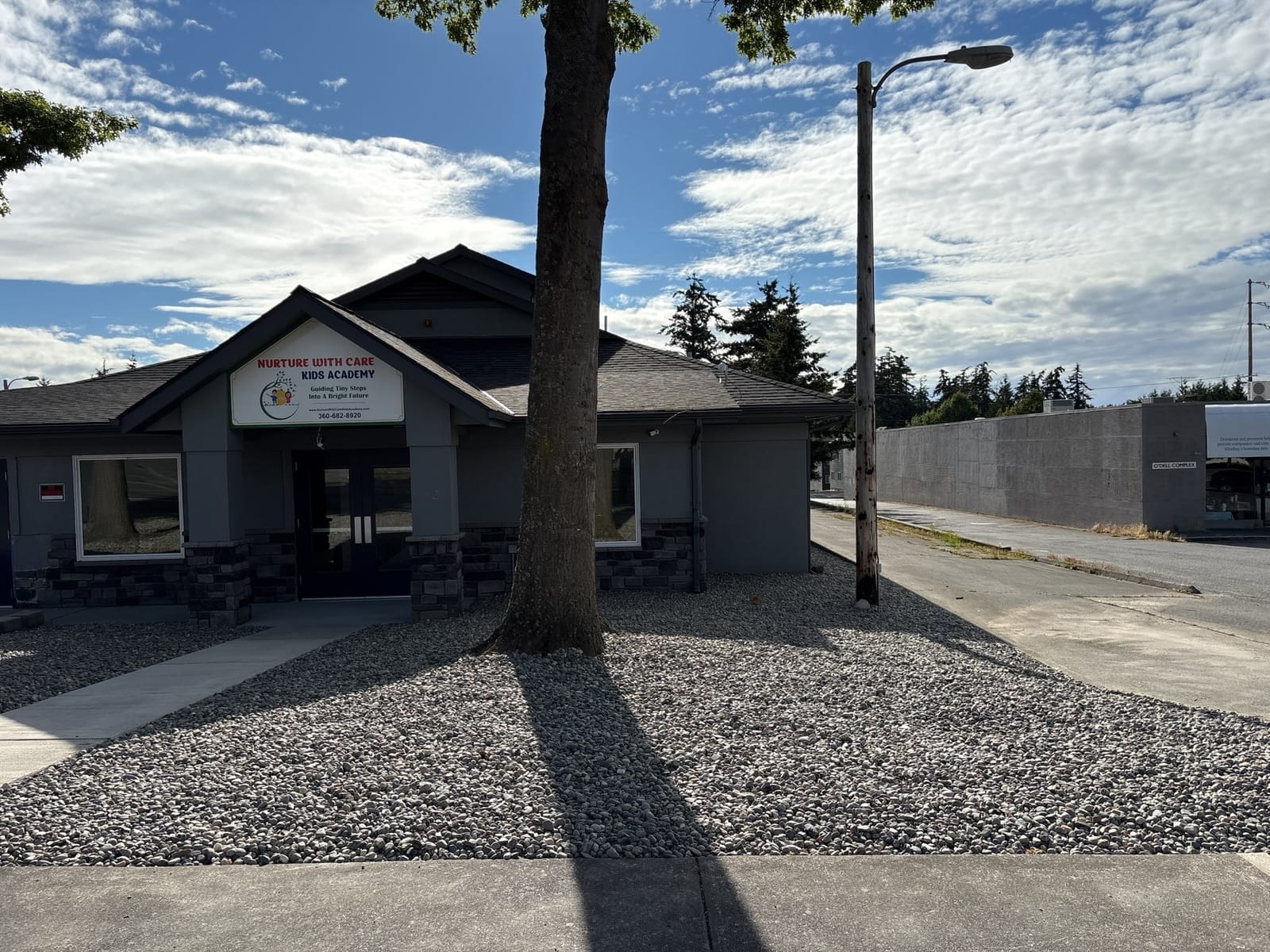 Front of the Midway Blvd building with branded signage and stone accents