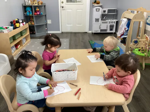 Young toddlers doing art activities in classroom at Nurture with Care Kids Academy Oak Harbor